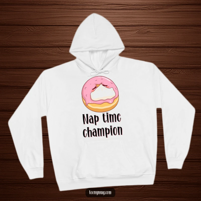 Funny hoodie showcasing a sleepy donut cuddling a tiny whipped cream pillow, symbolizing comfort and sweet dreams.